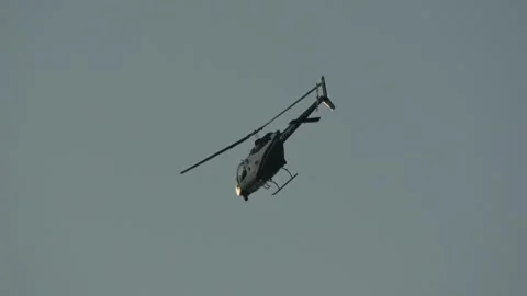 Slow motion video of law enforcement helicopter patrolling over city in evening Stock Footage 346472855