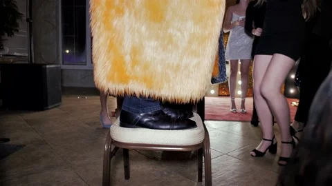 Slow motion video of legs of a dancing man who is standing on a chair Stock Footage 231236565