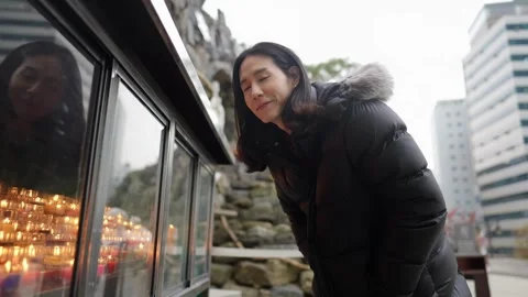 Slow-motion video of a long-haired Korean man in his 30s praying to the goddess Stock Footage 261493433
