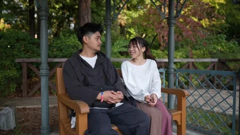 Slow-motion video of a man and a woman in their 20s sitting Stock Footage 264085503