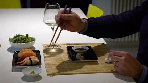 Slow motion video of  man with a beard eating sushi and drinking white .. Stock Footage 71563788
