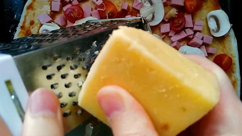 Slow motion video. man grates cheese over pizza. High quality footage in warm Stock Footage 129462098