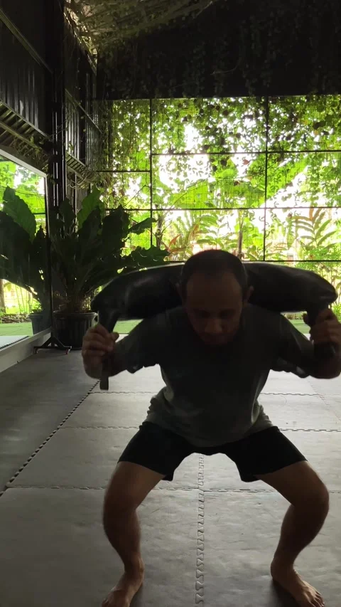 Slow Motion Video Of A Man Performing Squats With A Sandbag On His Shoulders Stock Footage 345706049