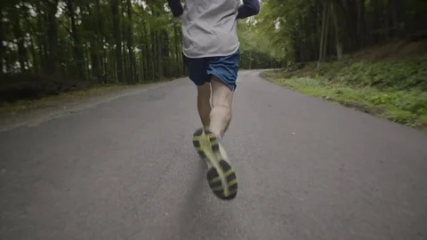 Slow motion video of man running in the woods Stock Footage 72183076