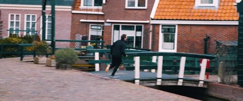 Slow Motion Video of Man Running Up Bridge in Quaint Volendam Stree Stock Footage 260929605