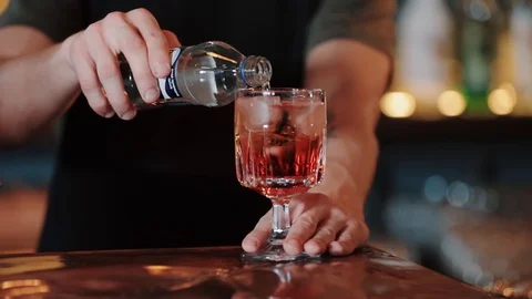 A slow motion video of a mixologist making an Aperol-Spritz cocktail. pours Stock Footage 128291780