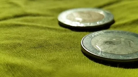 Slow-motion video of money while falling on bed with sun's light giving shadows Stockbeeldmateriaal 143773696