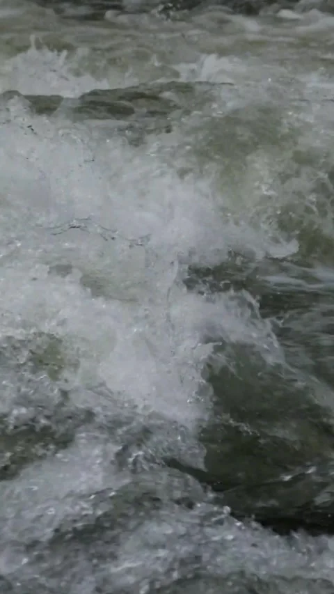 Slow motion video of mountain river water passing through a rocky cascade Видео 297716179
