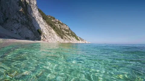 Slow motion video over clear turquoise water at Spiaggia di Sansone beach, .. Stock Footage 318968545