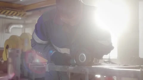 Slow motion video. Overall plan. Working man in overalls works with angle Stock Footage 262611119