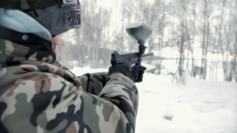 Slow motion video of a paintball player girl in winter walking through the snow Stock Footage 231807402