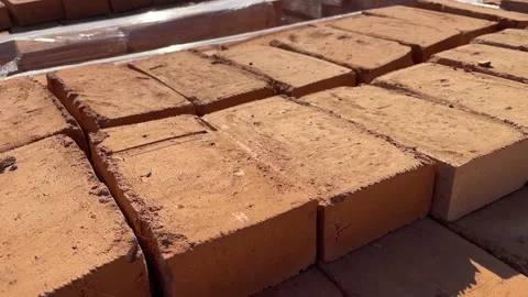 Slow motion video with pallets of solid red bricks at a construction site. Stock Footage 219692804