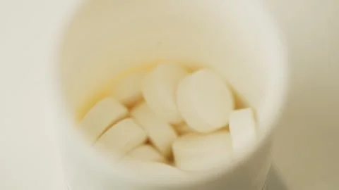 Slow motion video of pills falling into a box. Video stock 278828222