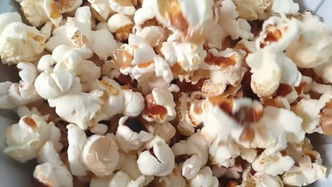Slow motion video of popcorn falling into plastic container. Video stock 159503612