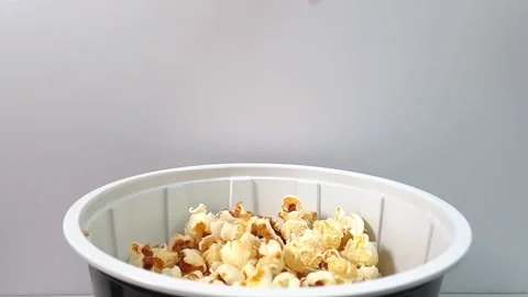 Slow motion video of popcorn falling into plastic container. Stock Footage 159503616