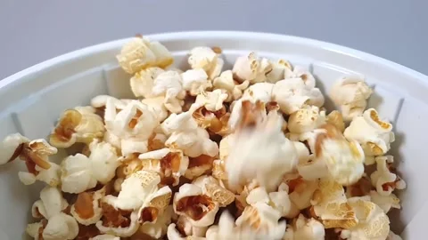 Slow motion video of popcorn falling into plastic container. Video stock 159503621
