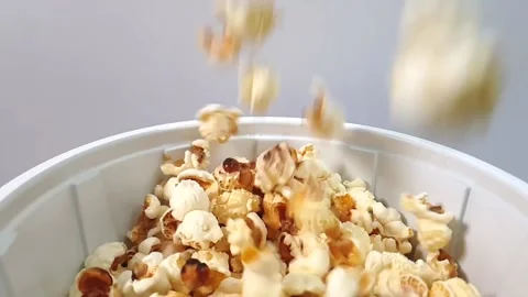 Slow motion video of popcorn falling into plastic container. Video stock 159503622