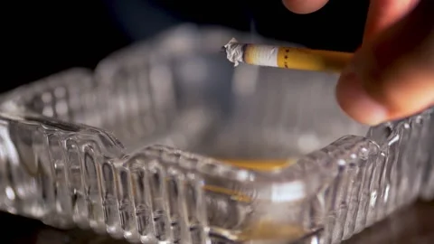 Slow motion video of popping ash into an ashtray Stock Footage 155366305
