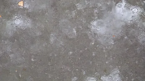 Slow motion video of raindrops falling onto the asphalt on a rainy day Stock Footage 155770231