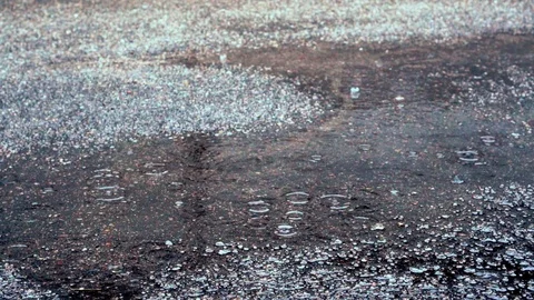 Slow motion video of raindrops in a puddle on the pavement Stock Footage 117695359