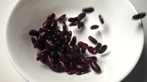 Slow motion video of Red Kidney Bean dropping into white ceramic bowl. Stock Footage 161910401