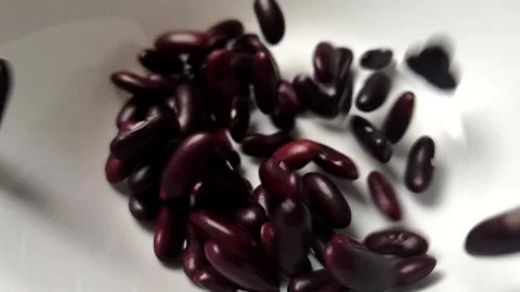 Slow motion video of Red Kidney Bean dropping into white ceramic bowl. Stock Footage 161910658