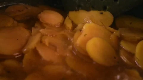 A slow motion video of red potatoes slices being stirred while cooking Video stock 337435174