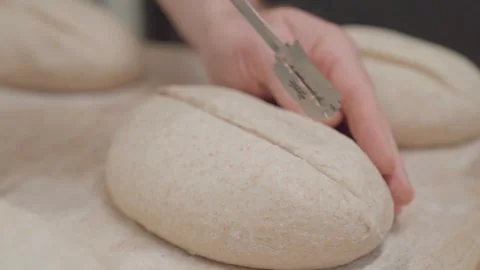 Slow motion video of scoring bread before fermentation with a baker knife Stock Footage 274256520