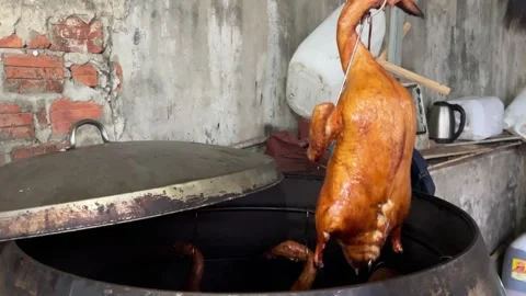 This slow motion video shows the hands of a cook hanging roasted duck in a Stock Footage 308138913