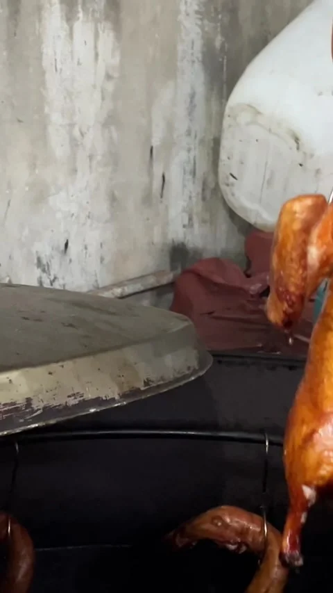 This slow motion video shows the hands of a cook hanging roasted duck in a Vídeo Stock 308338341