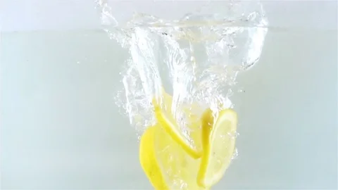 Slow Motion Video of Sliced Lemon Pieces Falling in Water with Spalsh Stock Footage 82407284
