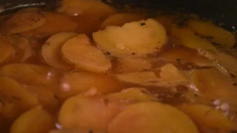 A slow motion video of small fresh picked red potatoes slices being cooked Video stock 337435177