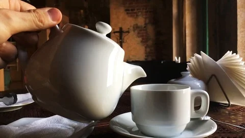 Slow motion video of tea pouring from a teapot into a cup (shot in a cafe) Stock Footage 88850118