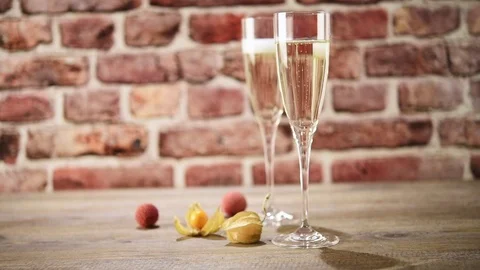 Slow motion video of two flutes of champagne on the wooden table with t.. Stock-Footage 70739264