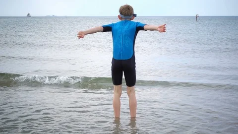 Slow-motion video of two happy children in neoprene swimsuits  playing with w Stock Footage 111659071