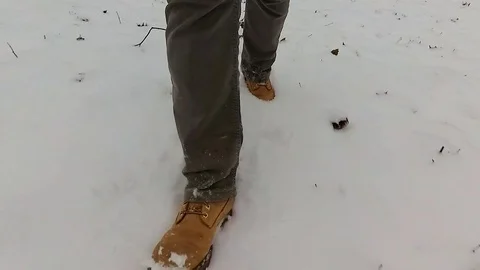 Slow-motion video of walking man on snow. Stock Footage 70621751