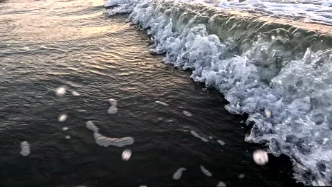 Slow motion video of a wave rolling towards the beach Stock Footage 336934796