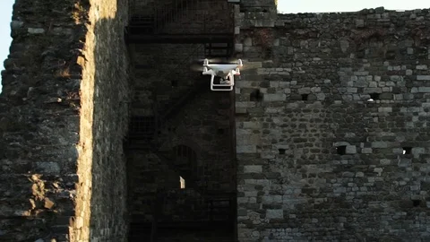 Slow motion video of a white quadcopter drone hovering in an ancient i.. Stock-Footage 73959630