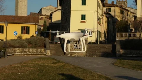 Slow motion video of a white quadcopter drone hovering in an ancient ita Stock Footage 82645047