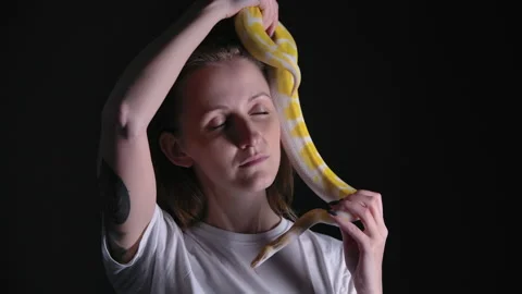 Slow motion video of woman with python albino crawling on her head Stock Footage 144481100