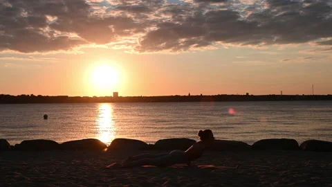 Slow motion video of a young woman doing yoga workout on Baltic sea coastline Video stock 209799853