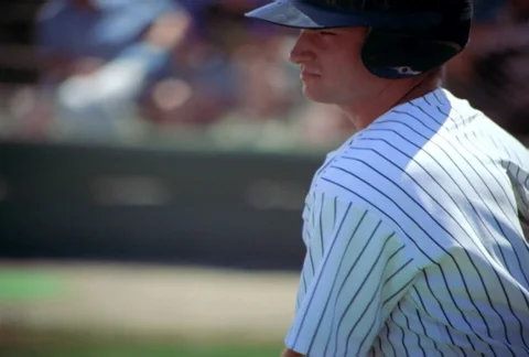 Slow-motion view of baseball player swinging two bats, one weighted at tip Stock Footage 86882534