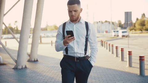Slow motion view of busy focused on phone Caucasian bearded man walking by Stock Footage 115668789
