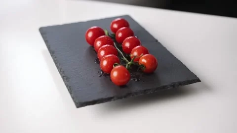 Slow motion view of cherry tomatoes falling on the plate. Fresh vegetables Stock Footage 231568740