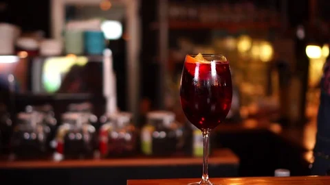 Slow motion view on classic red wine cocktail in alcohol drink glass on wooden Stock Footage 104373918