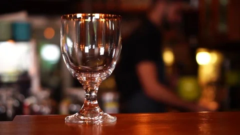 Slow motion view on clear transparent clear beer glass on wooden bar table in Stock Footage 103742689