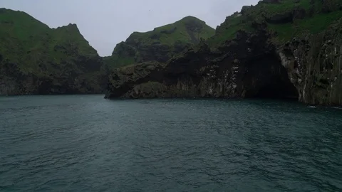 Slow motion view of cliffs in ocean - Vestmannaeyjar Iceland Видео 72332397