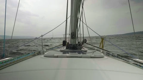 Slow motion view of coastline, stormy water of river and boats on it. View from Stock Footage 80220516