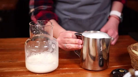 Slow motion view on coffee making process with milk in tin cup and glass jar on Stock Footage 104541282