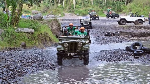 Slow motion view of driving four wheel drive jeep in gravel and water path Stock Footage 127340605